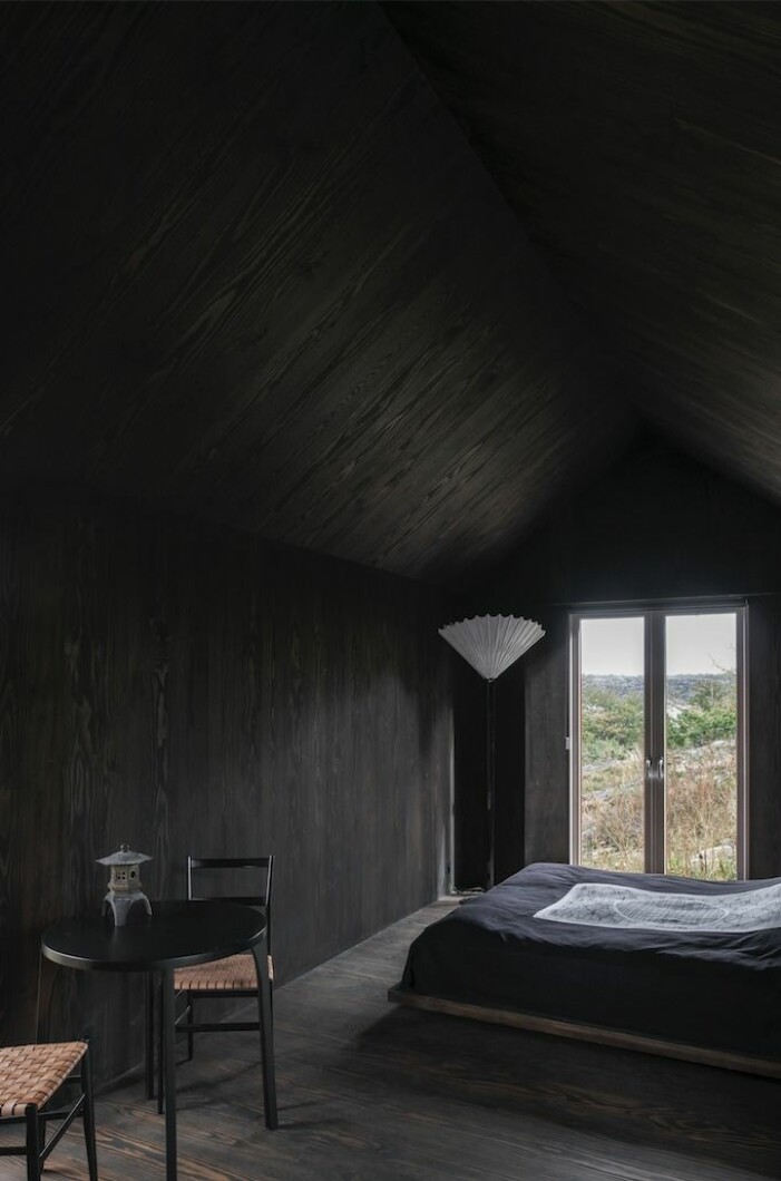 I gästhuset gäller helt svart inredning, inspirerad av Gerts resor till Japan. Sängöverkast och lampa i design av Karin Wingårdh. Wingårdhs gård Äggdal, gästhus med helt svart inredning.
