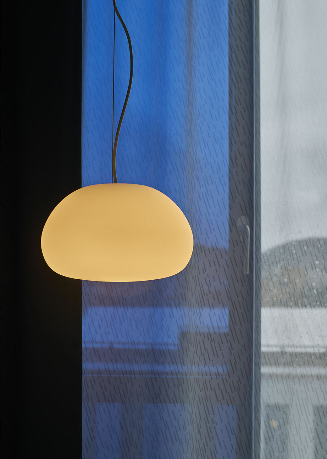 På nybyggda Zander K regnar det alltid när man drar för gardinerna, en av alla detaljer som tar fasta på regnet som ofta kopplas till Bergen. Lampa och gardin på Zander K i Bergen